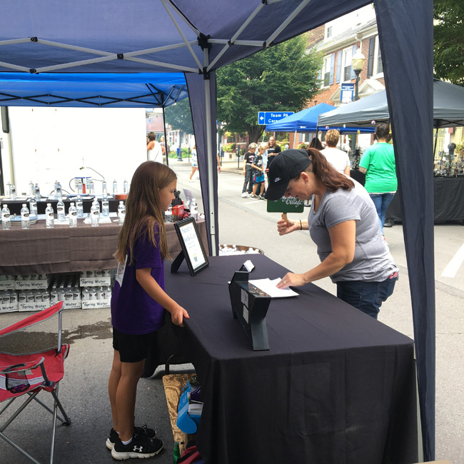 Sarah selling a copy of her book at a festival